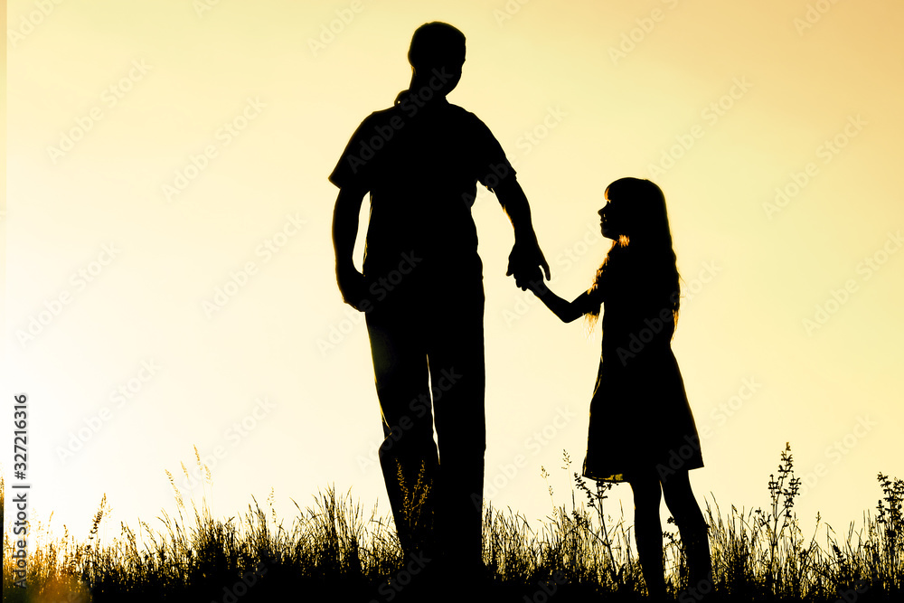 happy parent with child in the park outdoors silhouette