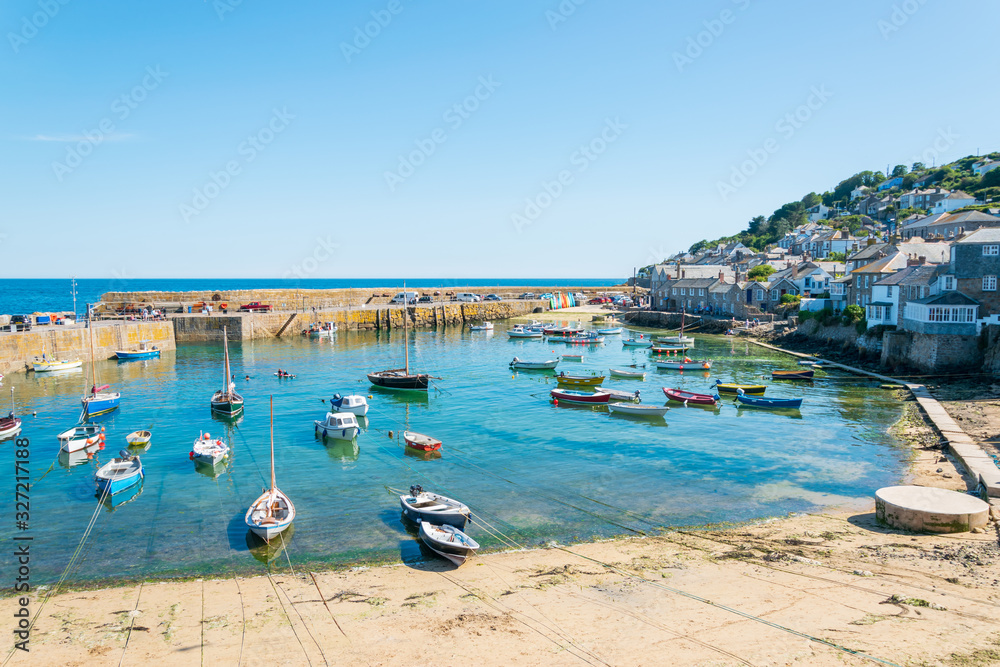 Boats moored in Mousehole Harbour, a picturesque Cornish fishing village near Penzance in Cornwall, England