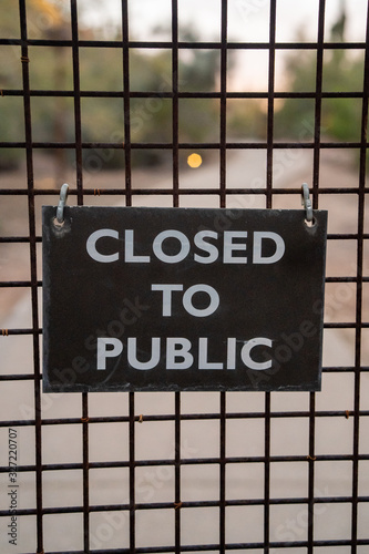 rustic sign on gate that says closed to public