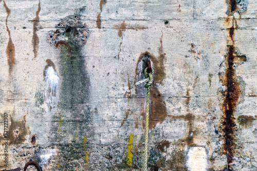 Rusty, old and weathered details on concrete harbour wall. Grunge, creative, texture, industrial and rustic look concept.