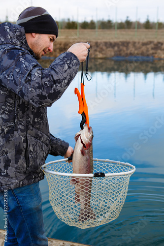 Foto The fisherman catches the fish by net from the lake