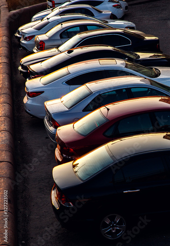 Car parked at concrete parking lot of shopping mall in holiday. Aerial view of car parking area of the mall. Automotive industry. Automobile parking space. Global automobile market concept.