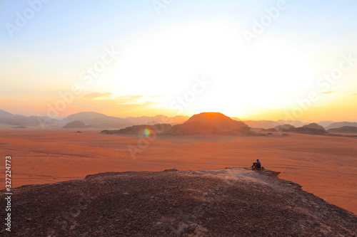 silhouette of man on top of the mountain at sunset on the Wadi Rum red desert in Jordan