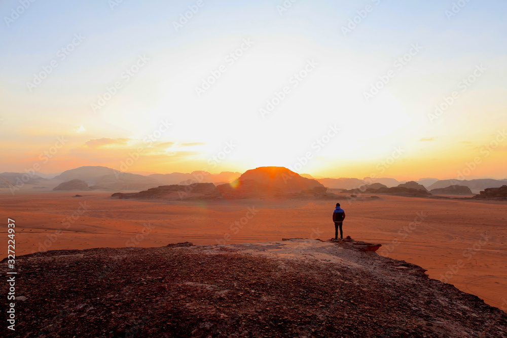 silhouette of man on top of the mountain at sunset  on the Wadi Rum red desert in Jordan
