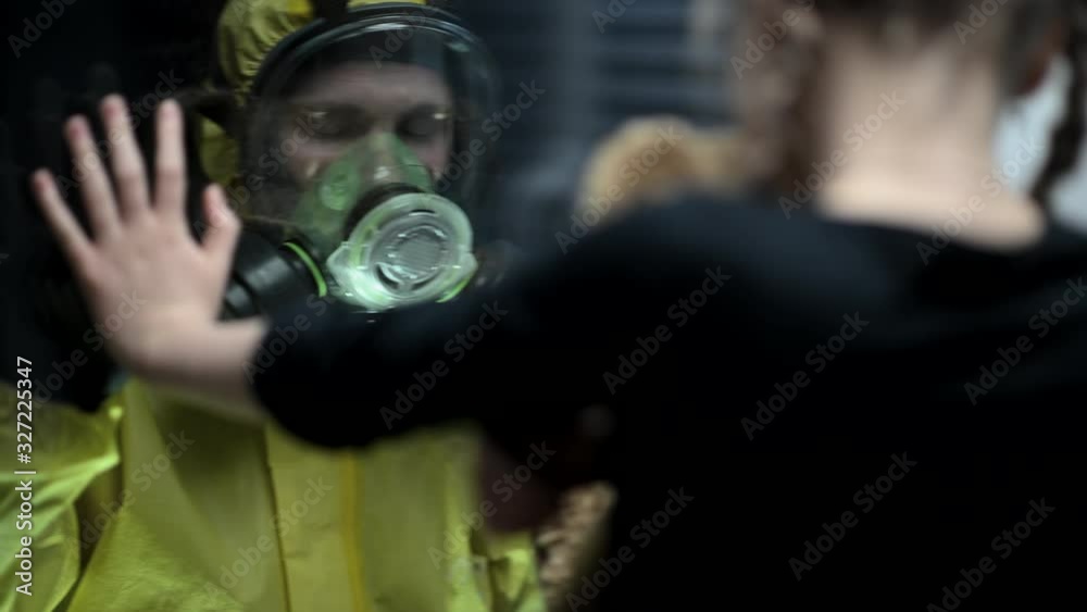 Sad Daughter Touches Glass Window. Contaminated Father In Full Protective Suit Stands Alone In Isolation Room And Says Silent Goodbye To Child.