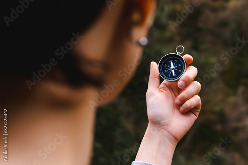 young girl holding a compass in hand, ready to travel, keep calm. Tourism, traveling, hiking and healthy lifestyle concept.