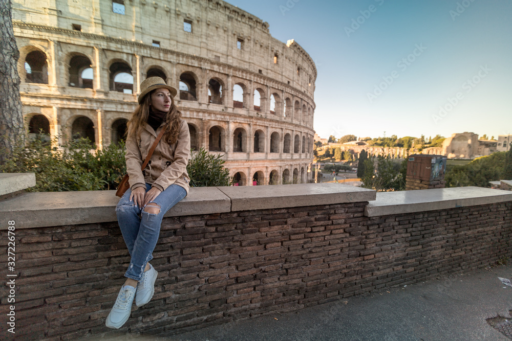 Roman Holiday. Portrait of happy young woman in the front of Colosseum in Rome, Italy