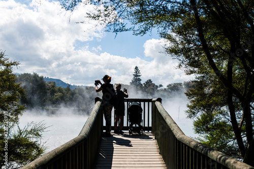 women tourists looking at steam of hot springs in rotorua