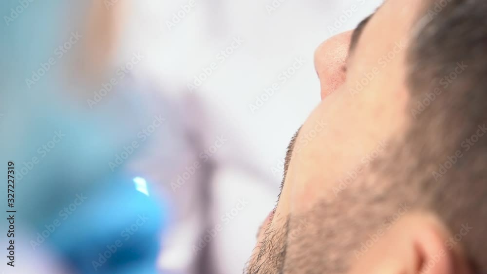 Close-up of a professional dentist using dental equipment working with a male client at a dental clinic. no face shot Close-up of a professional dentist using dental equipment working with a male client at a dental clinic. no face shot