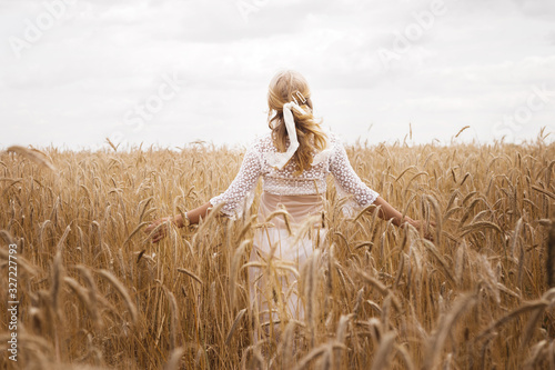 girl in a wheat field in summer. back view