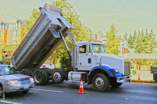 Truck  dumper  in urban traffic. A city in the USA. Roadworks.