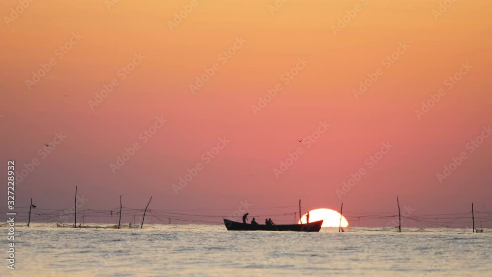 Fisherman boat silhouette floating on sea golden sun rising, hard working Fisherman boat silhouette floating on sea golden sun rising, hard working