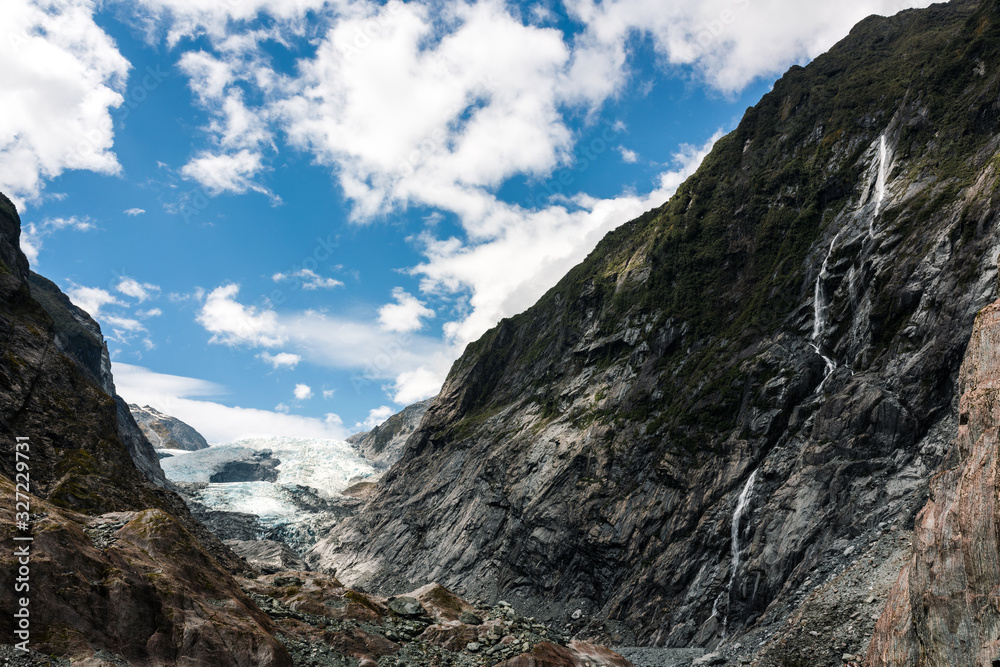 franz josef glacier with mountains and blue sky