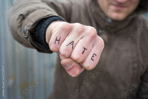 Konstfotografi Faust mit dem Wort Hass in englischer Sprache als Symbol für Hass und Brutalität