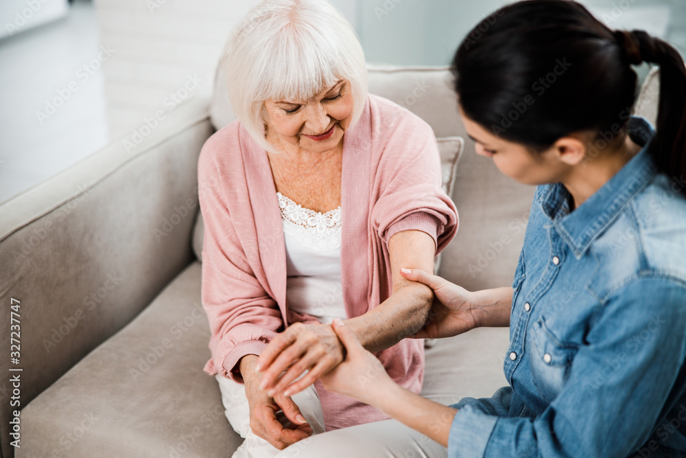 Obraz premium Family doctor holding arm of elderly woman
