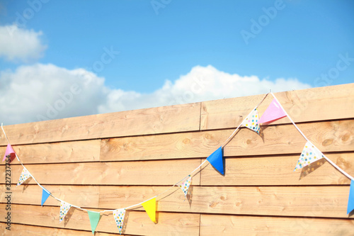 Wooden planks wall background with a birthday party flags slinger photo