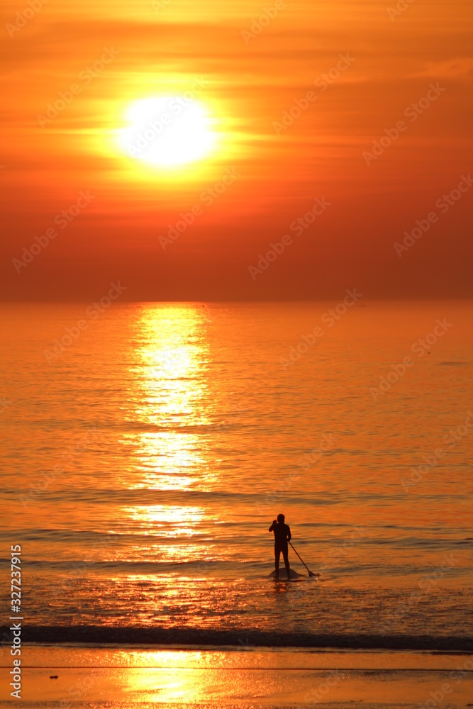 silhouette of man on beach at sunset