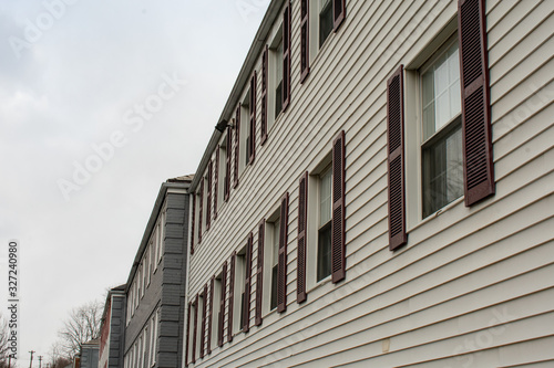 Repeating Windows With Red Shitters At an Angle With a Gray Sky in the background photo
