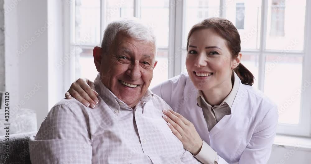 Caring smiling female caregiver embracing happy senior patient, closeup portrait Caring smiling female caregiver embracing happy senior patient, closeup portrait