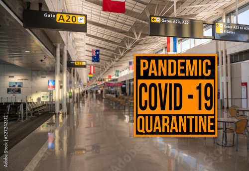 Pandemic sign warning of quarantine due to Covid-19 or corona virus in the USA against background of empty airport terminal photo