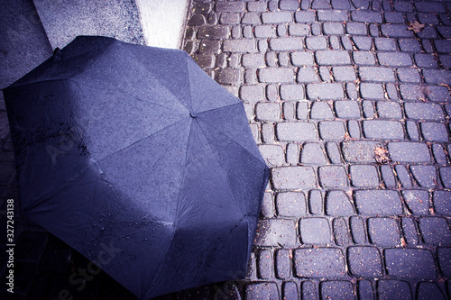 Umbrella in the rain lies on the street.