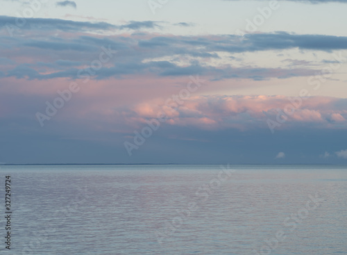 Pink and Blue Rain Clouds Over the Calm Water at Sunset