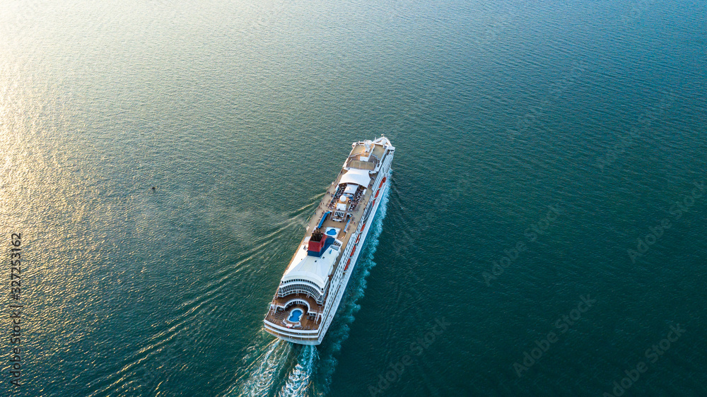 Aerial view Cruise ship at sunset in ocean, Aerial view large cruise ship at sea, Passenger cruise ship vessel, sailing across the Gulf of Thailand. Aerial view Cruise ship at sunset in ocean, Aerial view large cruise ship at sea, Passenger cruise ship vessel, sailing across the Gulf of Thailand.