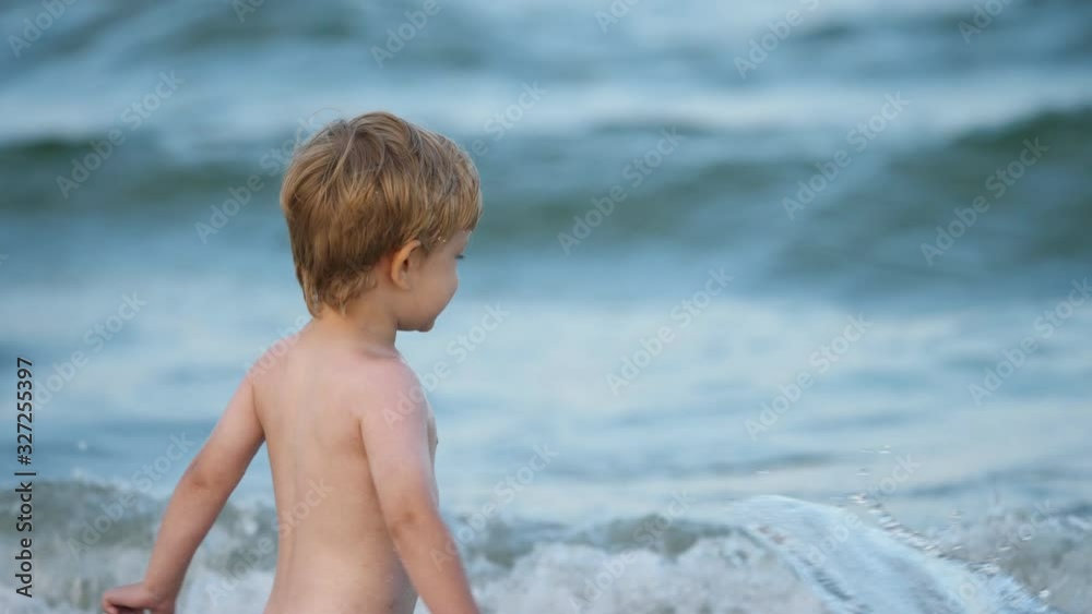 Little child splashing blue sea water, funny free toddler, summer holiday Little child splashing blue sea water, funny free toddler, summer holiday