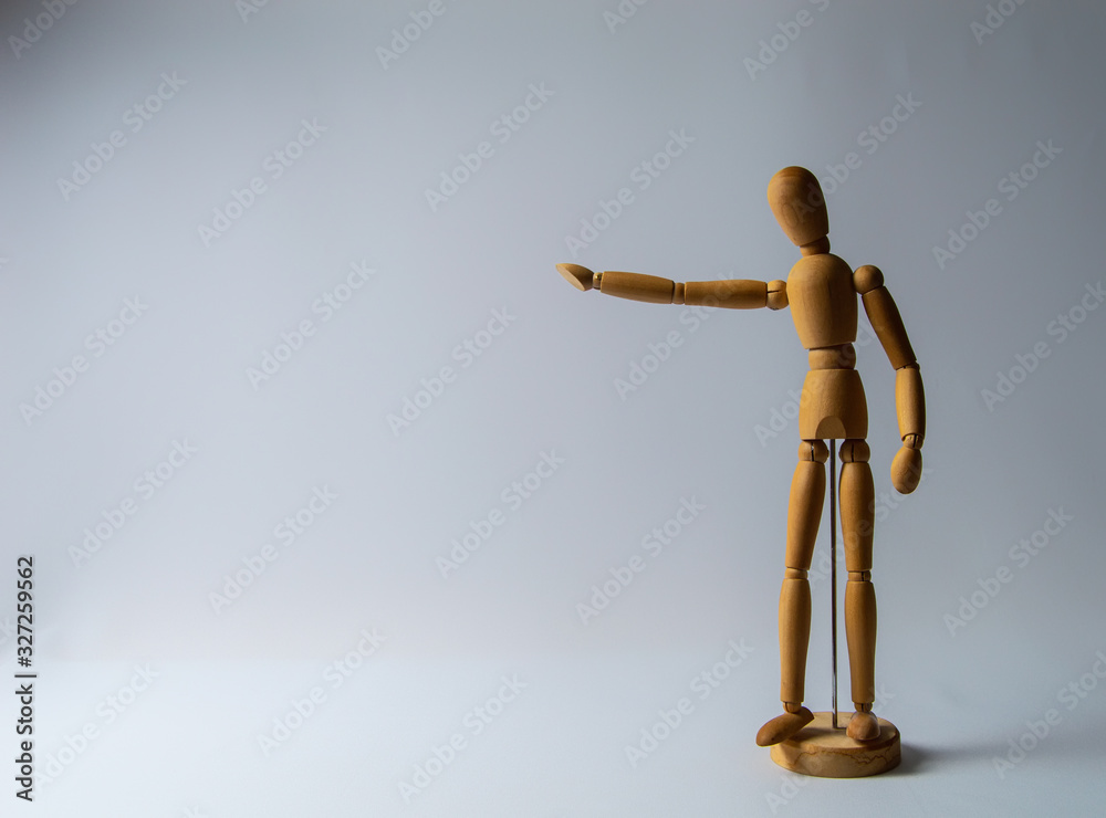 Wooden dummy stands on white background with hand raised Wooden dummy stands on white background with hand raised