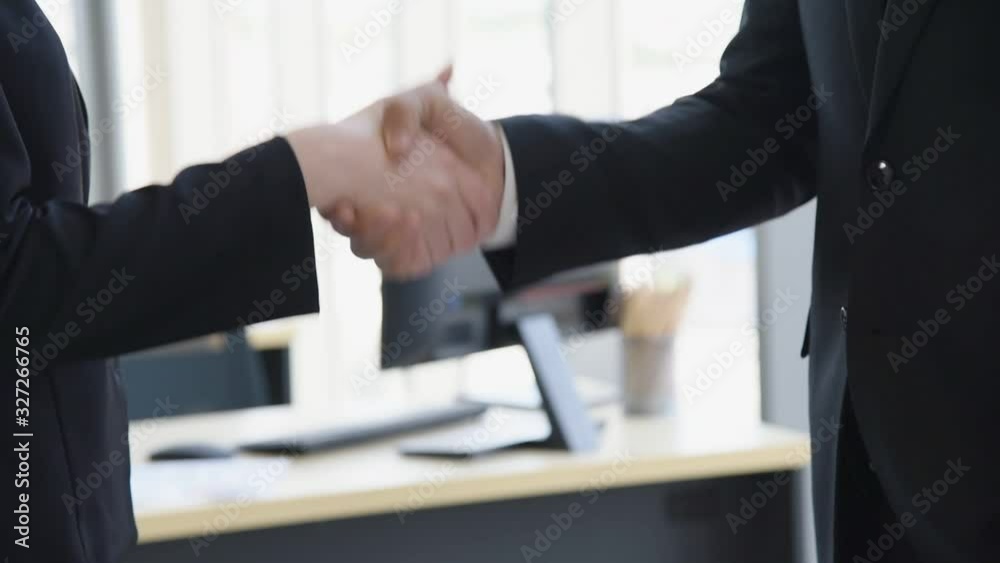 Professional business people man and woman shake hand with modern office in background, Slow motion footage