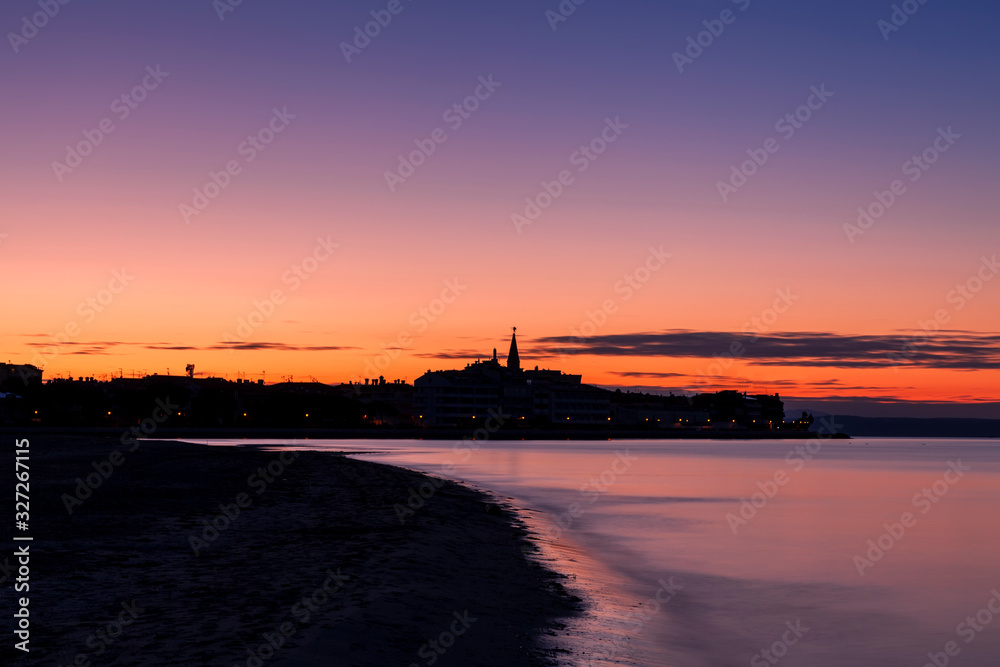 Alba sulla città di Grado vista dalla laguna. Provincia di Gorizia, Friuli Venezia Giulia, Italia, con cielo e mare colorato.