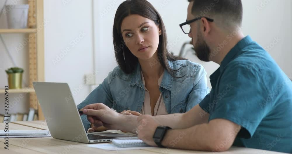 Thoughtful employees working on project together in office. Thoughtful employees working on project together in office.