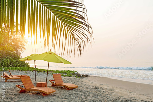 Beach chair under the big umbrella and was on the beach. Beautiful beach. Chairs on the sandy beach near the sea. Summer holiday and vacation concept for tourism. Inspirational tropical landscape.