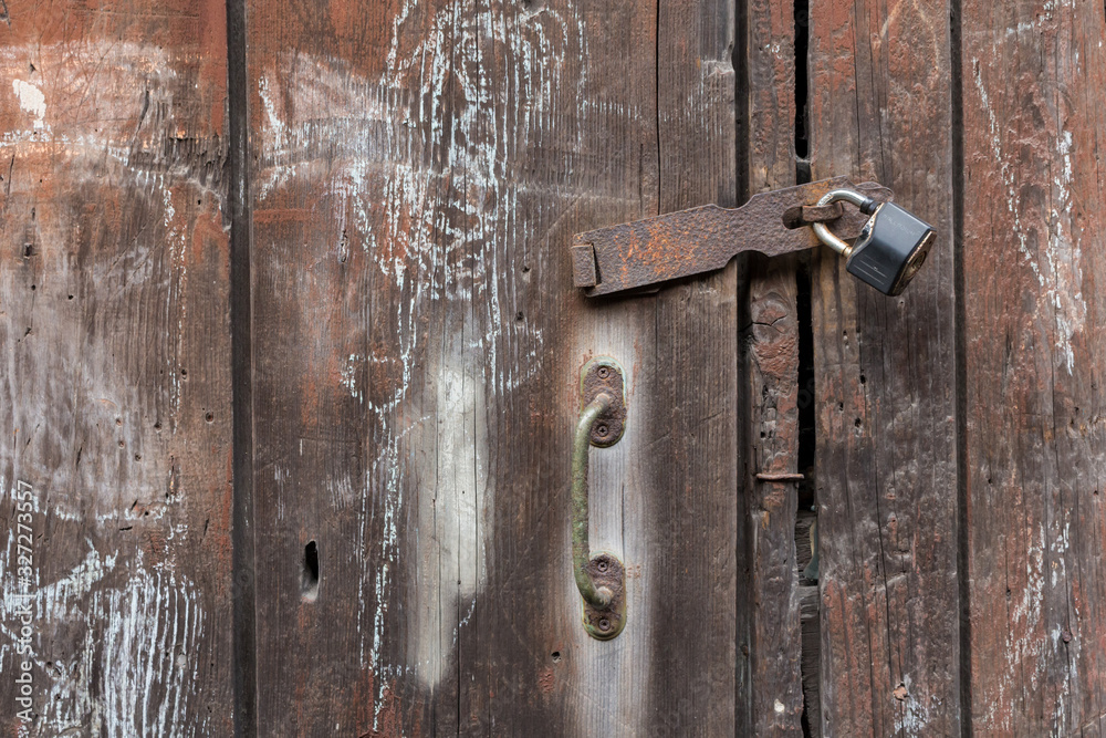Old padlock on a wooden painted wall, old rusty door handle