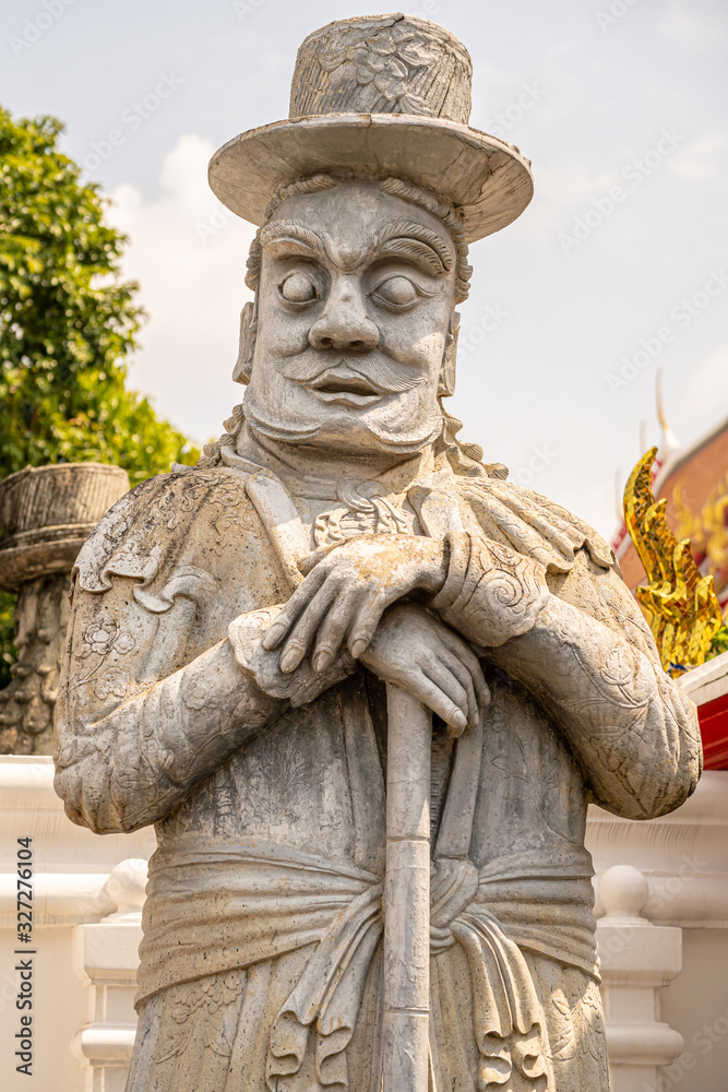 Fototapeta premium Chinese dolls dressed in western style stone statues At Wat Pho or Phra Chetuphon Wimon Mangkararam Temple an ancient temple in Bangkok, Thailand
