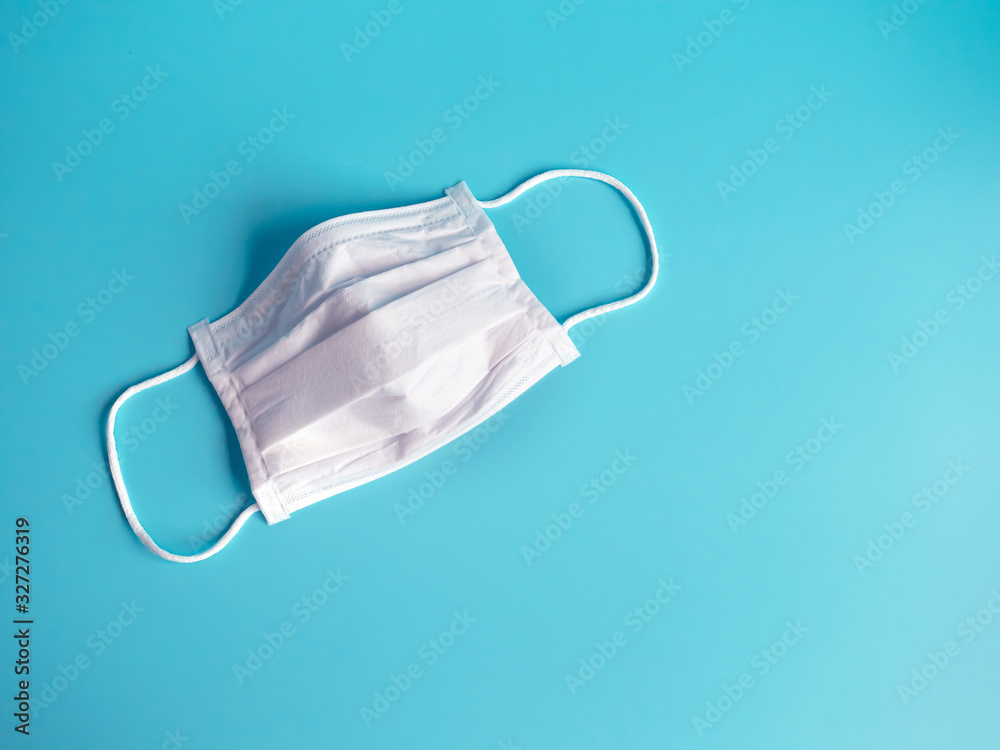 close up white surgical face mask on blue green background , equipment mask to protect man health from flu , a coronavirus infection , Health care concept
