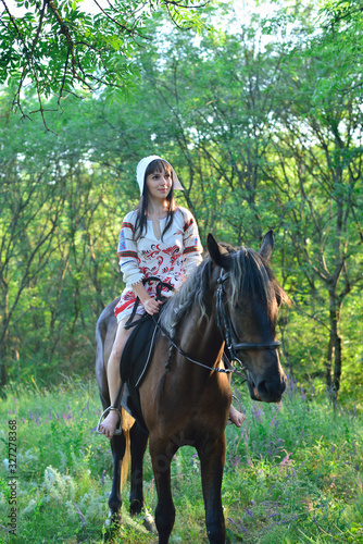 Girl in an ancient russian attire riding a horse © Arestov Andrew