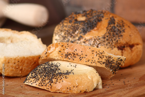 Sliced kaiser bread roll with poppy seed photo