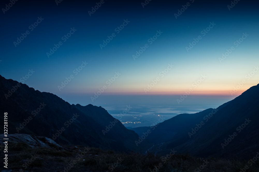 High view of a mountain valley with town below at sunrise
