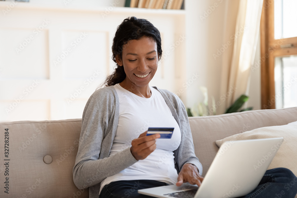 Happy biracial woman shopping online using laptop Happy biracial woman shopping online using laptop