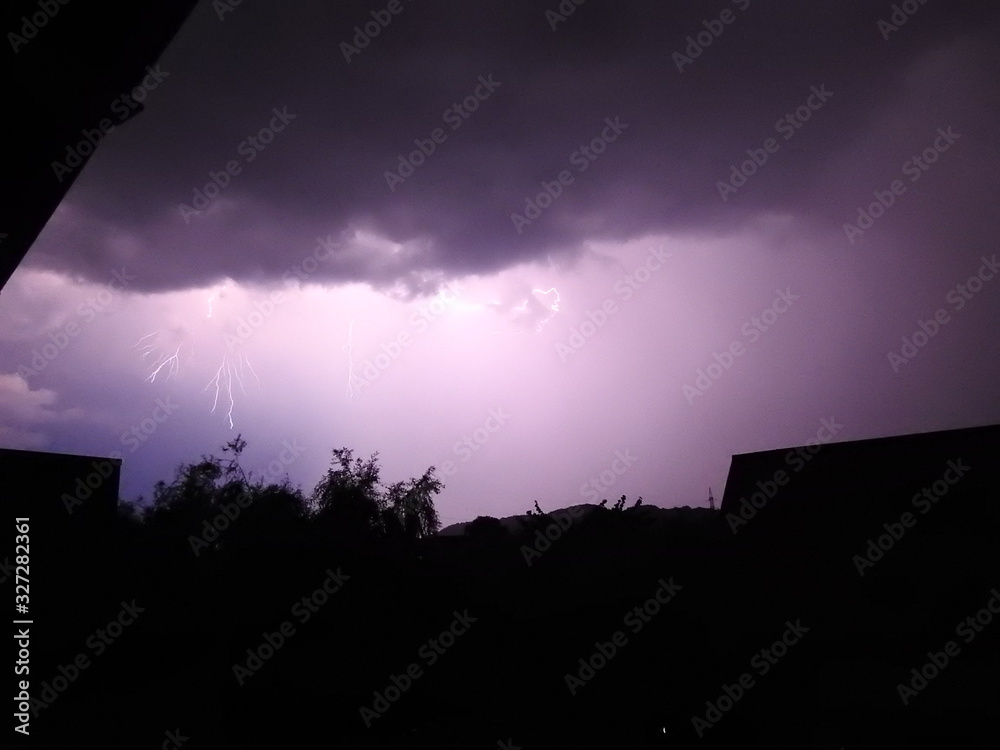 Lightning making the sky purple over a residential area