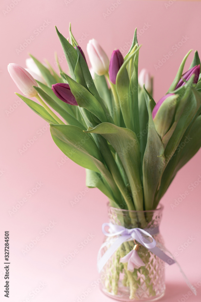 Obraz premium bouquet of pink and purple tulips in a vase on pink background, spring flowers for women, copy space