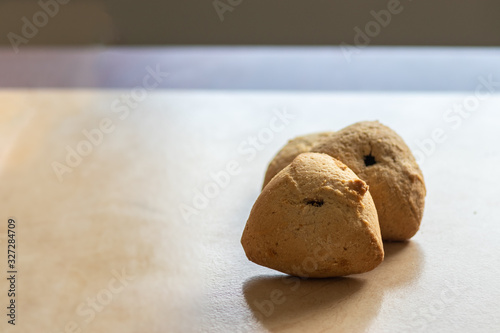 ozney haman (Haman Ear) Triangular pastry made of crispy dough stuffed. Traditional Jewish food for Purim. Located on a wooden surface photo