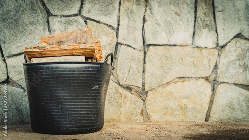 Canvas Print black bucket full of wooden logs
