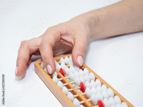 Classes in mental arithmetic  hands and abacus soroban on white background. closeup. copy space