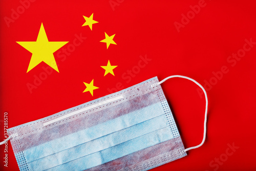 Medical mask on the background of the Chinese flag. Disposable face masks for viruses, Coro novirus. photo