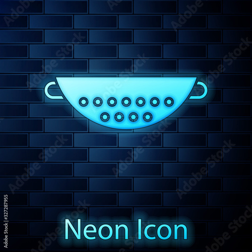 Glowing neon Kitchen colander icon isolated on brick wall background. Cooking utensil. Cutlery sign. Vector Illustration