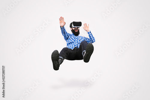 cheerful bearded man in glasses virtual reality levitating on gray background photo