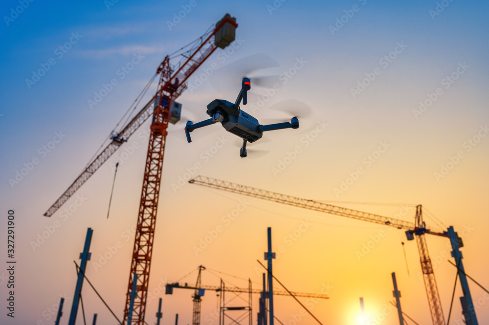 Drone over construction site. video surveillance or industrial inspection - obrazy, fototapety, plakaty 