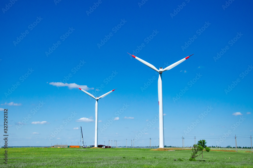 Fototapeta premium Wind turbines on green field blue sky clouds green energy concept renewable energy generator